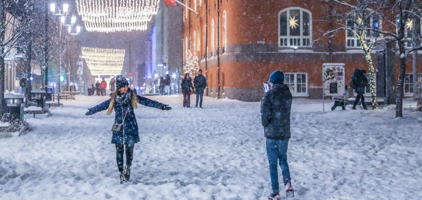 Two people playing in the snow in the main street of Tromsø