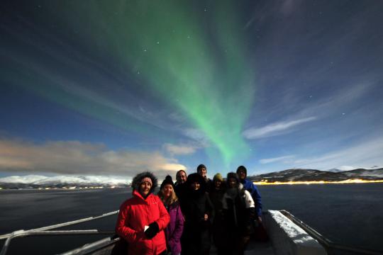 Guests on deck with Northern Lights in the background