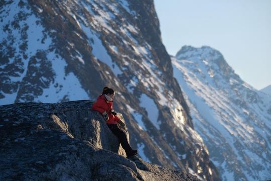 person enjoying the view of snow covered mountains