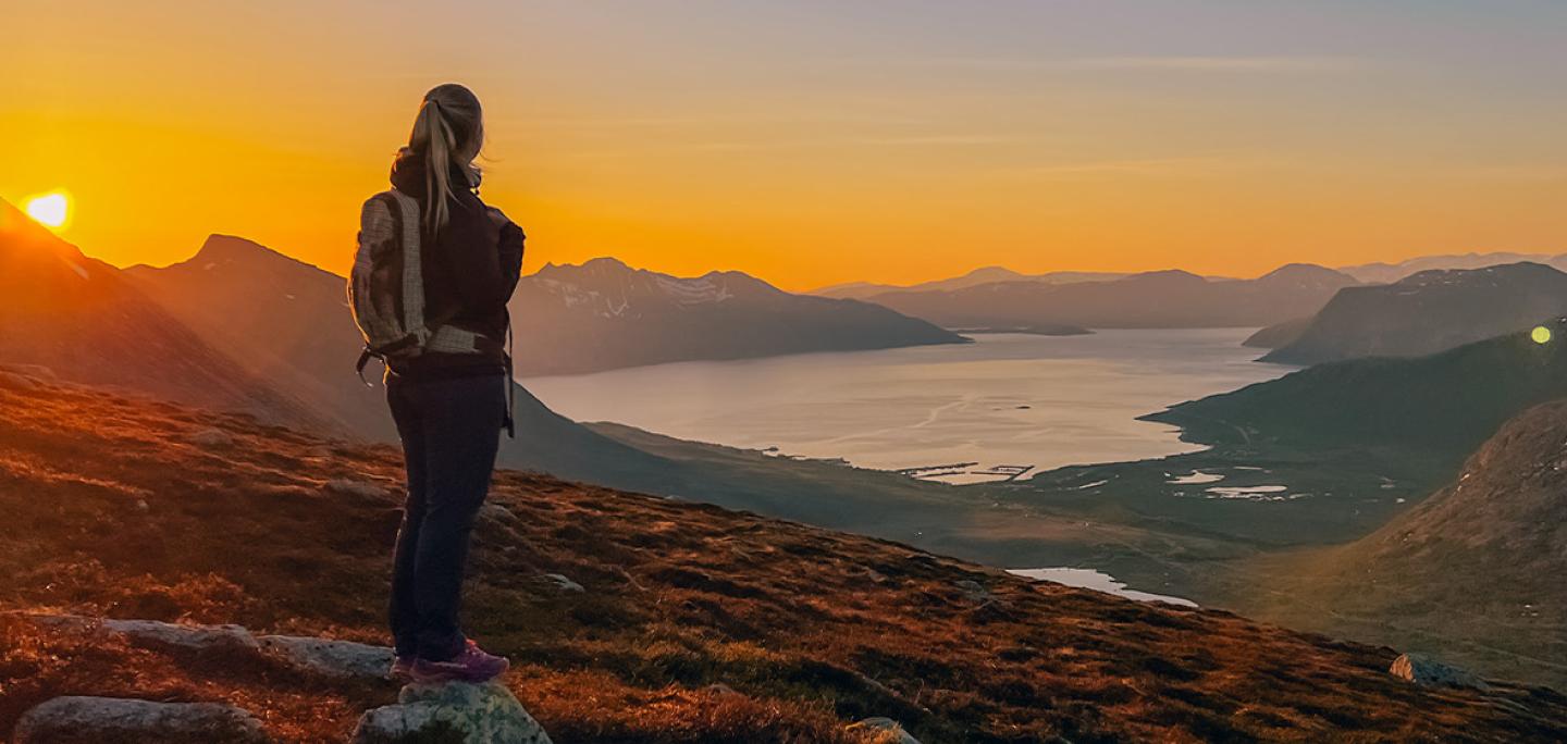 Woman enjoying the midnight sun and view from Kvaløya 