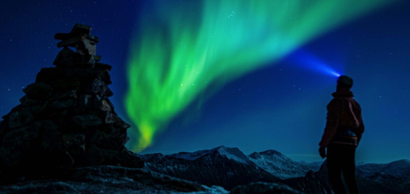 Man in mountains see Northern light