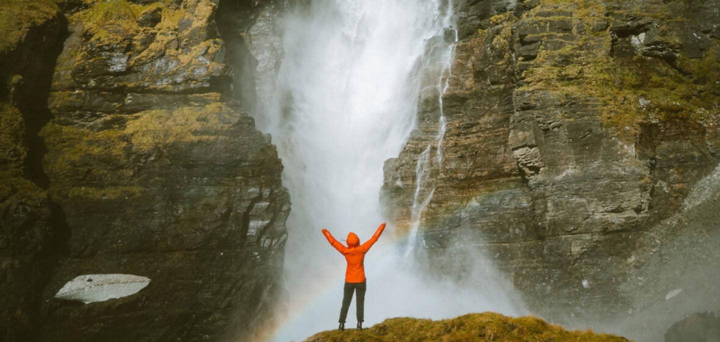 Person standing in front of a waterfall