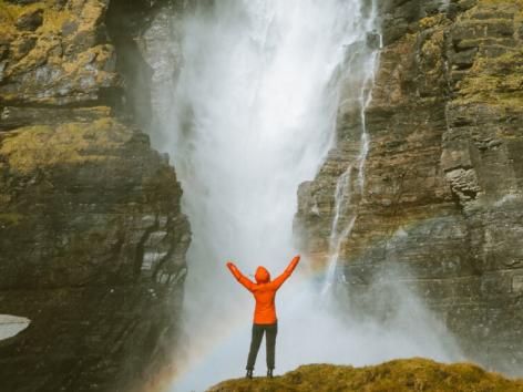 Person standing in front of a waterfall