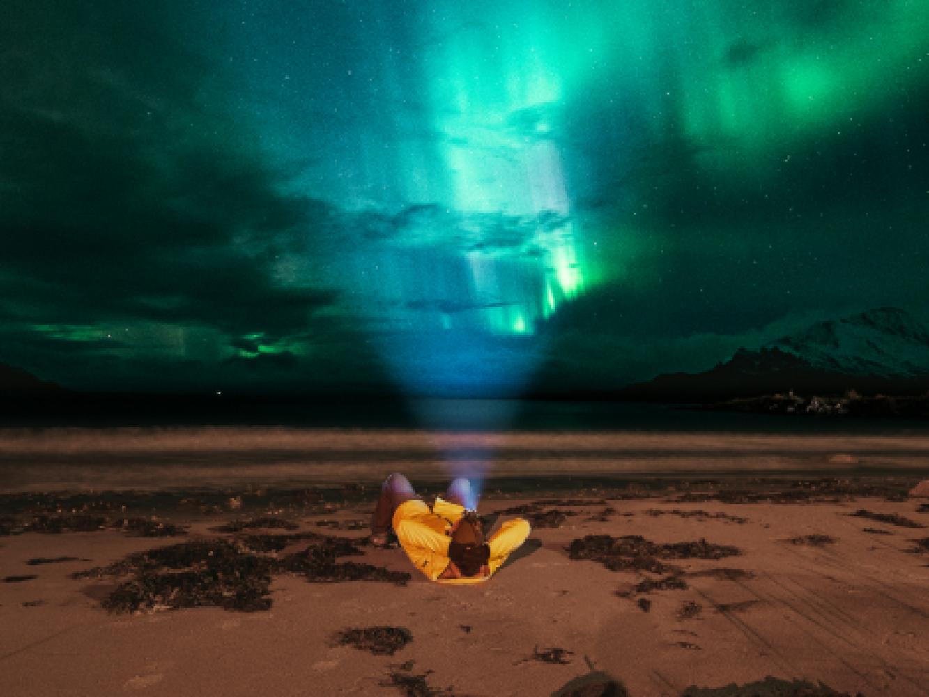 Enjoying the northern lights from a beach in the Tromso region