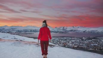 Girl walking in winter sunset with a Tromsø view