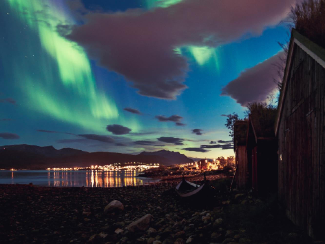 Northern lights above Tromsø seen from the sea shore