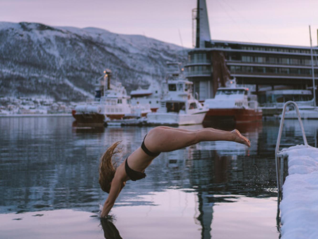 woman refreshing dip in ocean by Pust sauna in Tromsø